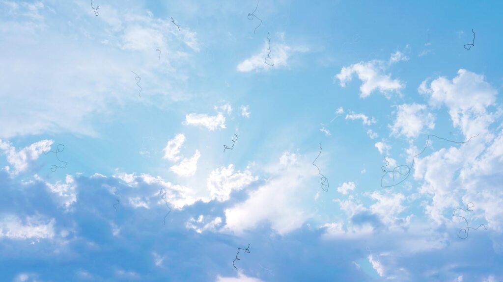 Blick in den blauen Himmel mit angedeuteten schwebenden Punkten und Fäden als Darstellung von Mouches volantes